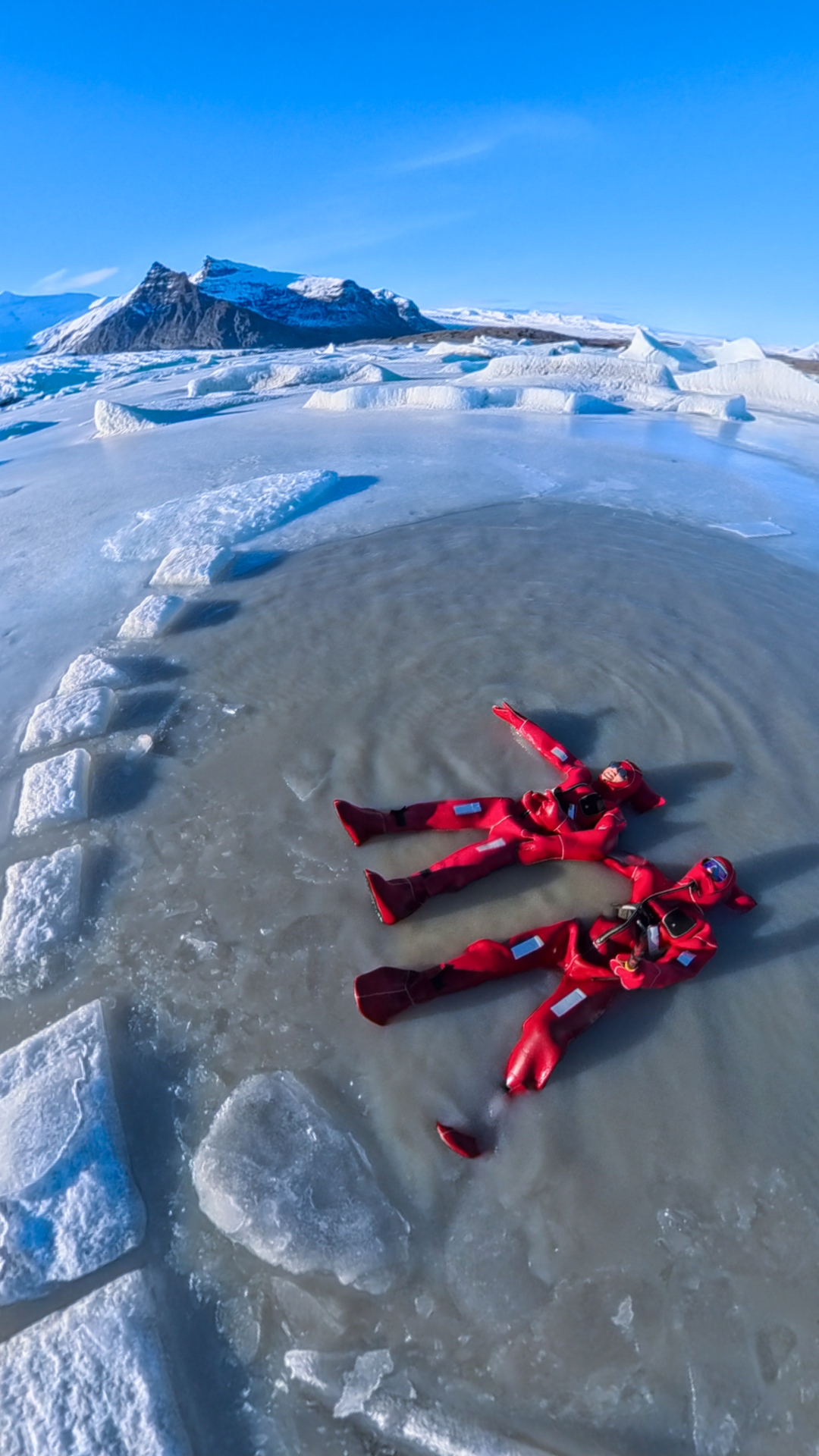 Glacier lagoon in Iceland with floating icebergs and mountains in the background